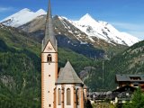 Alpy, kostel ve vesnici Heiligenblut, v pozadí hora Grossglockne